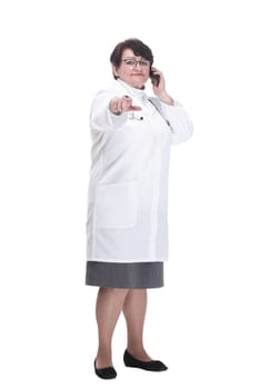 in full growth. senior female medic with a smartphone. isolated on a white background.