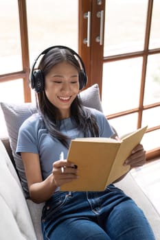 Portrait woman takes notes while listening to online meeting.