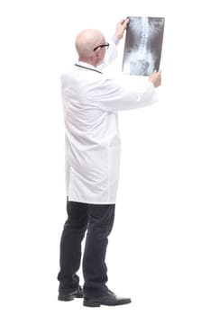 senior doctor with a stethoscope looking at an x-ray. isolated on a white background.
