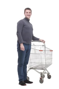 in full growth. casual young man with shopping cart. isolated on a white background.