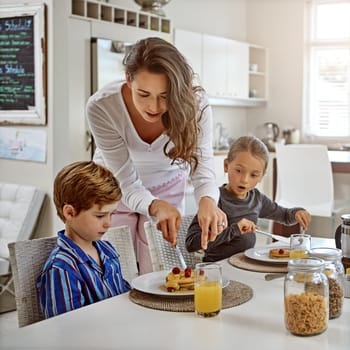 Youre spoiling the fun mom...two children having breakfast with their mother