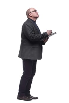 side view. focused business man making notes in the clipboard. isolated on a white background