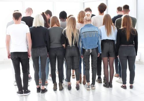 rear view. a large group of young people looking at a large white screen. photo with copy space