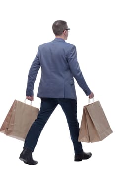 Back view of going handsome man with shopping bags. Isolated over white background.