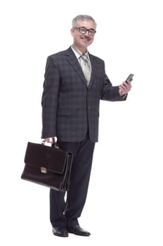 in full growth. a man with a briefcase reading the SMS on his smartphone. isolated on a white