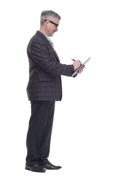 in full growth. business man making an entry in the clipboard. isolated on a white