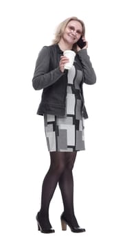 in full growth. a woman with a takeaway coffee talking on her smartphone . isolated on a white background