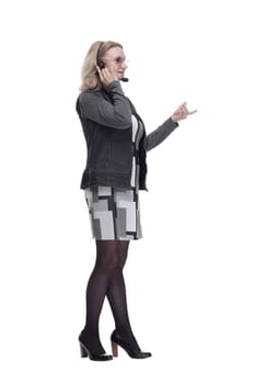 in full growth. an attractive woman in a headset looking at a white screen. isolated on a white