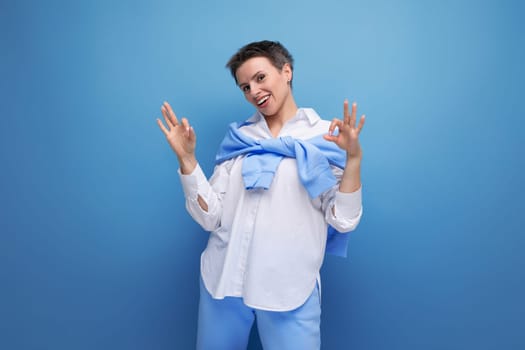 stylish young dark-haired woman with sticking hair in a white shirt.