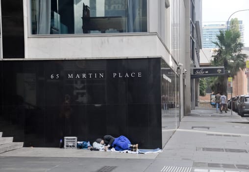 SYDNEY, AUSTRALIA - APRIL 14, 2019: Reserve Bank of Australia at 65 Martin Place on black granite wall in Sydney Australia with a homeless man sleeps nearby