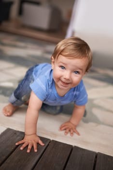 The cutest smile. an adorable little infant crawling on the floor