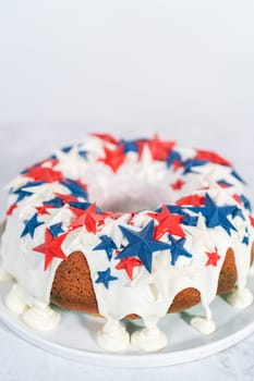 July 4th bundt cake covered with a vanilla glaze and decorated with chocolate stars on a white plate.