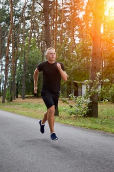 young athlete running in the forest, motion blur. with a sun flare