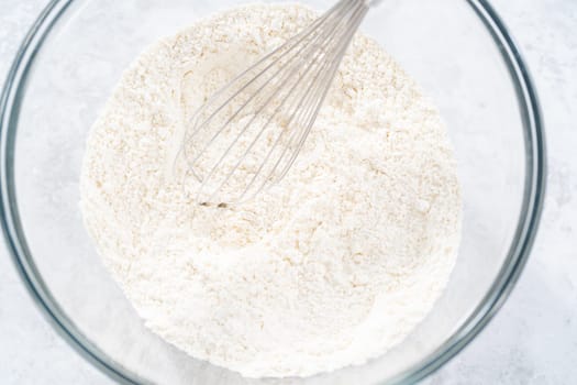 Mixing ingredients in a glass mixing bowl to bake July 4th bundt cake with chocolate stars.