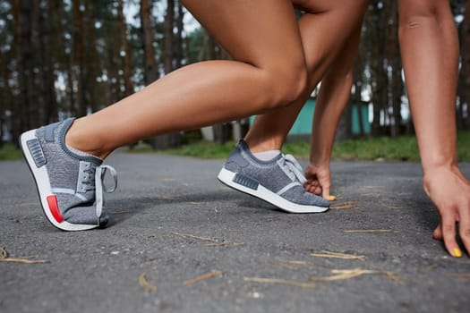 Young woman running outdoors in a city park on. It is preparing to start . close-up