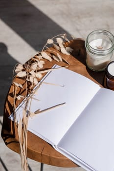 Magazine and book mockup design. Blank magazine on modern wooden table with candles , shadow overlay. Mockup soy wax candle in natural style.