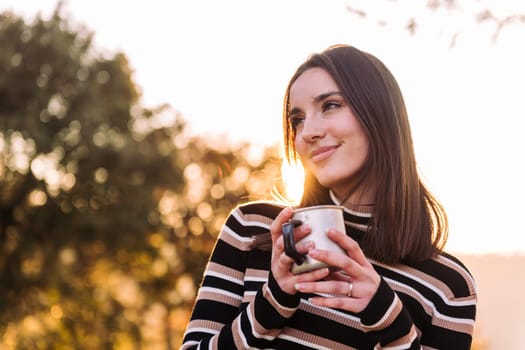 young woman embraces the outdoors finding peace with tea in the morning, concept of nature's warmth and wilderness lifestyle, copy space for text