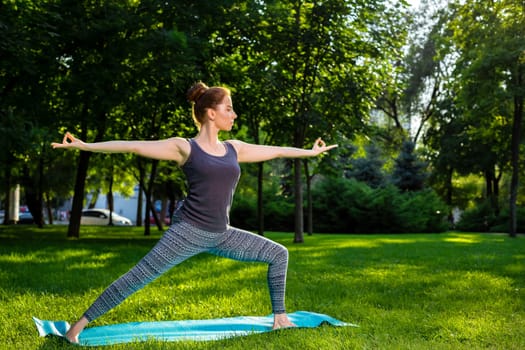 Young fitness woman meditation in a city park.Yoga at sunset in the park. Girl is practicing yoga. Fitness training outdoors. Attractive fitness woman. Workout outdoors. Healthy lifestyle