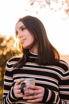 young woman embraces the outdoors finding peace with tea in the morning, concept of nature's warmth and wilderness lifestyle