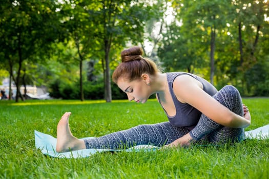 Young fitness woman meditation in a city park.Yoga at sunset in the park. Girl is practicing yoga. Fitness training outdoors. Attractive fitness woman. Workout outdoors. Healthy lifestyle