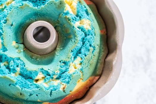 Cooling freshly baked bundt cake in bundt cake pan on the kitchen counter.