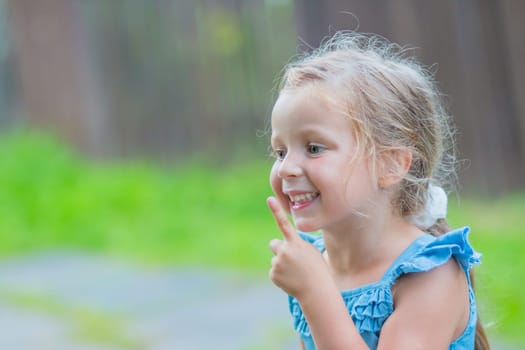 Sweet little girl, two years old. The girl smiles, looks into the camera. Blue eyes, blonde hair.