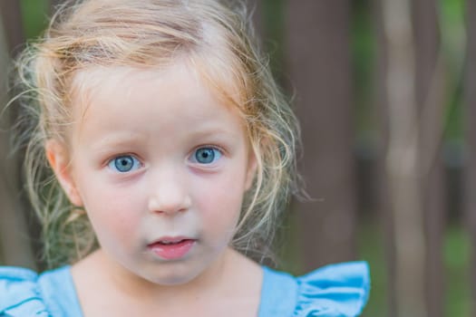 Sweet little girl, two years old. The girl smiles, looks into the camera. Blue eyes, blonde hair.