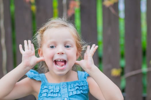 Sweet little girl, two years old. The girl smiles, looks into the camera. Blue eyes, blonde hair.