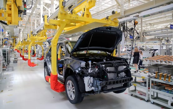 Factory for the production of cars, factory conveyor. Cars are being assembled.