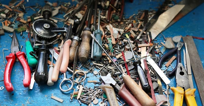 carpentry tools in a pine tree on the table. screws, spare parts for accordion repair.