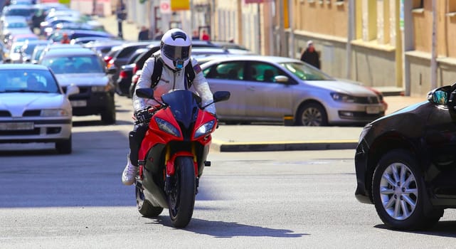 city traffic with motorcycle and cars. motorcyclist among cars at the crossroads.