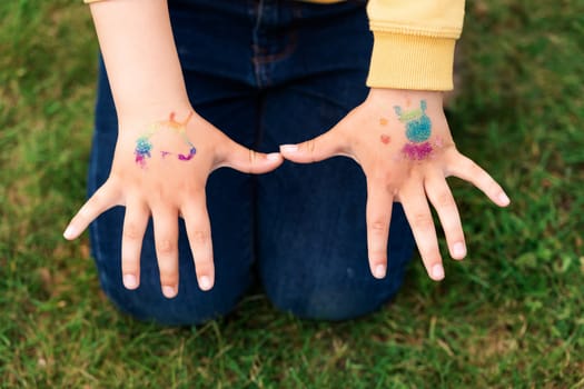 Shimmering sparkling glitter tattoo on a child's hand at a birthday party. Body art