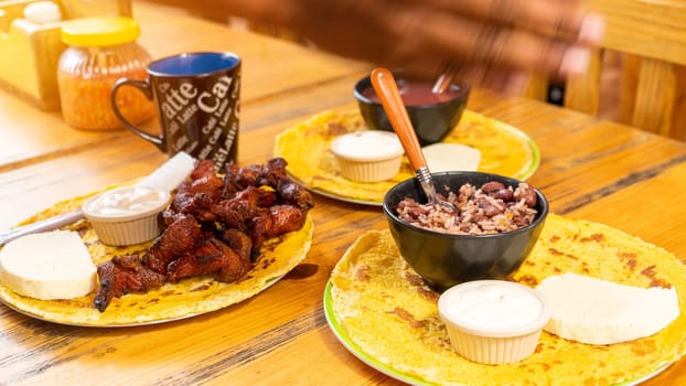 Food served for breakfast in Nicaragua, guirilas and fried pork with a cup of coffee