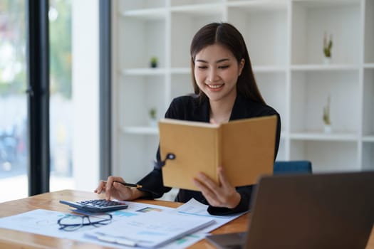 Young asian female work with financial papers at home count on calculator before paying taxes receipts online, planning budget glad to find chance for economy saving money, audit concepts.