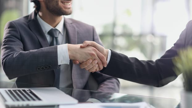 Happy business men giving handshakes after negotiations