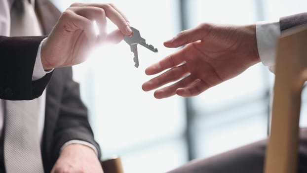 World leasing day concept. Realtor gives the keys to the new owner. Close-up of hands. Rental and purchase of real estate