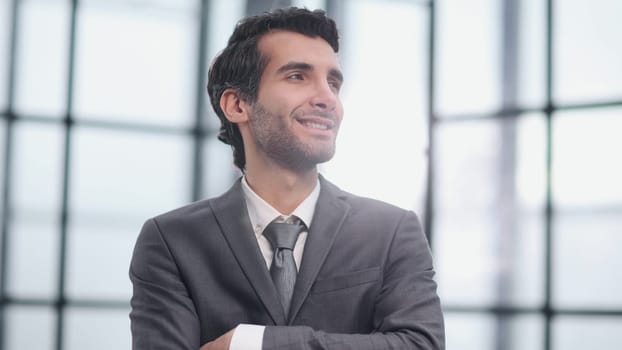 Portrait Of Businessman Standing By Window In Office