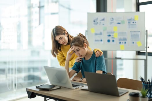 Asian women are stressed while working on laptop, Tired asian businesswomen with headache at office, feeling sick at work.