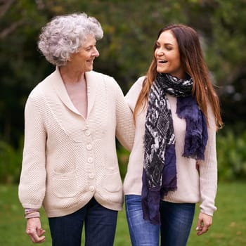 Smile, park and woman with elderly mother together on a outdoor vacation or holiday bonding in happiness. Retirement, women and young happy female person in conversation and laughing with mom.