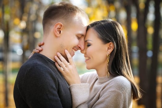 Portrait of young interracial couple in love in autumn park.