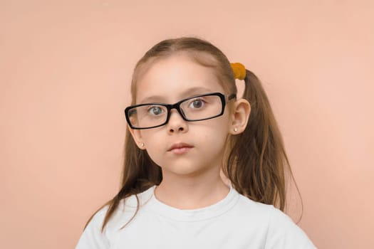 Portrait of a preschool girl in rectangular optical glasses.
