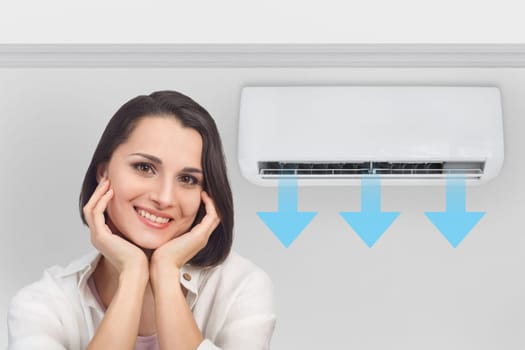 Portrait of a smiling happy woman in a bright fresh room with the air conditioner turned on.