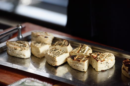 halloumi cheese on a steel tray. an ingredient for the saganaki dish