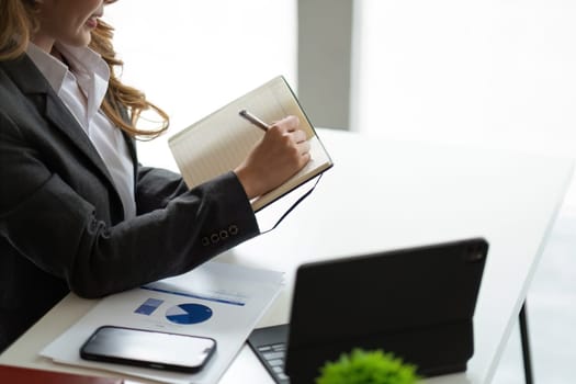 Close up business woman looking at laptop computer watching online webinar training or having virtual meeting video conference taking notes, doing market research working in office..