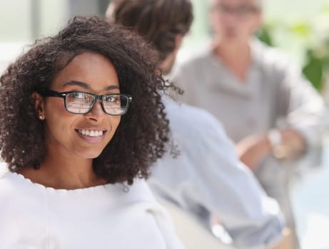 young attractive african american woman in the office sitting at the table