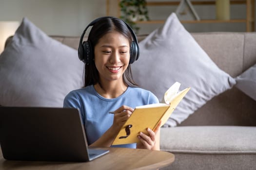 Portrait of young beautiful teenager happy funny Asian woman holding a book and listen the music, relaxing cute Asian chilling at home. High quality photo