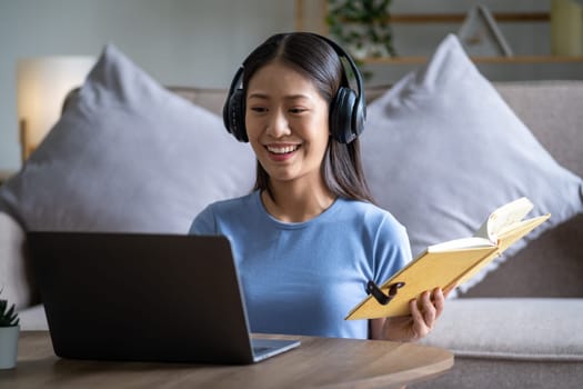 Portrait of young beautiful teenager happy funny Asian woman holding a book and listen the music, relaxing cute Asian chilling at home. High quality photo