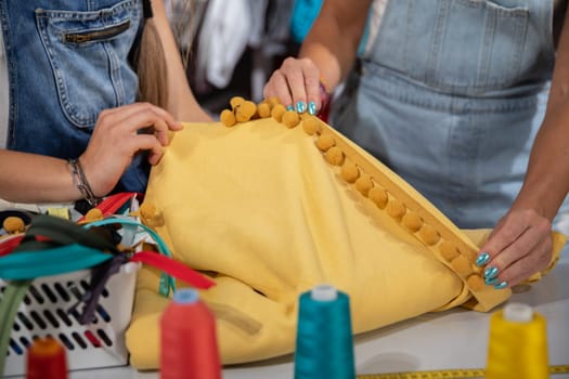 Two clothing designers while working together on one clothing project. Creative work in the back of the tailor's studio.