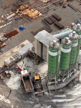 Construction site from above - trucks, construction workers, cisterns. High quality photo