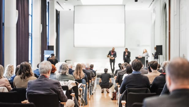 Business team leader receiving award prize at best business project competition event. Business and entrepreneurship award ceremony theme. Focus on unrecognizable people in audience